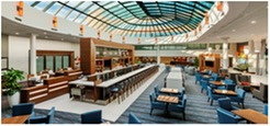 Panoramic photo of Huntington Hilton loft area with tables and chairs and a bar.